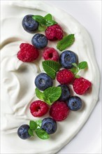 Breakfast, yogurt with fresh berries, raspberries and blueberries, on a white background, selective