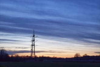 Electricity pylons and power lines in the sunset in Bohmte, Osnabrück district, Lower Saxony,