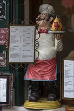 Cooking figure with fish in front of a restaurant, Burano, Veneto, Italy, Europe