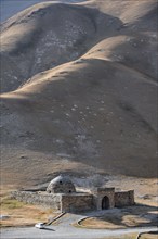 Historic caravanserai Tash Rabat from the 15th century, with yellow hills, Atbashy district in the