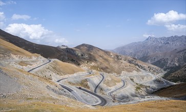 Winding roads on the Pamir Highway, mountain road through an eroded mountain landscape, Kyrgyzstan,