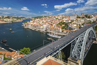 View of Porto city and Douro river with moored sailing ship and Dom Luis bridge I from famous