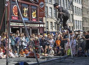 Street performers and spectators at a high-wire acrobatics performance, world's largest cultural