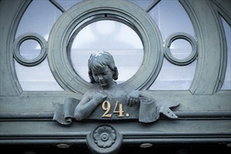 Detail of a historic door with bust of a girl and house number 24, Borups Højskole, school