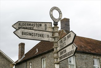 Road signpost arrow pointers and distances to nearby settlements, Kingsclere, Hampshire, England,