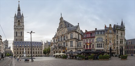 Historic buildings and bell tower at dusk on a lively town square, Ghent