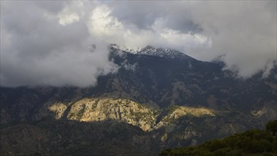 Mountain landscape with clouds and partly sunny rocks casting shadows, Lefka Ori, White Mountains,