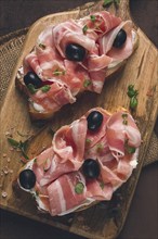 Breakfast, bacon and olives sandwich, on a cutting board, top view, close-up, no people