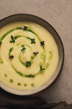 Mashed potatoes, with green butter and micro greenery, homemade, on a beige table, no people, top