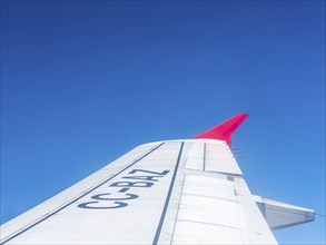 Wing aeroplane with red tip, blue sky