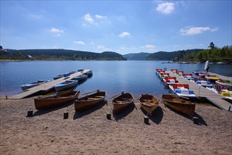 A picturesque scene with colourful pedal boats and wooden boats on a jetty in front of the