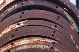 Close-up of rusted metal braces with drilled holes in junkyard, Quebec, Canada, North America