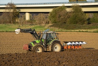 Farmer ploughing a field, tractor with plough, near Neuss, North Rhine-Westphalia, Germany, Europe