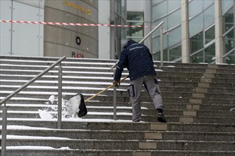 Onset of winter, winter service, clearing snow on the stairs of the Commerzbank building,