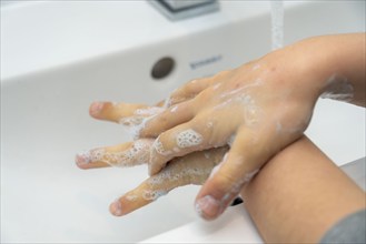 Domestic hygiene, washing hands, with a bar of soap, boy 9 years old