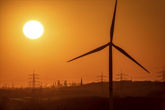 Wind turbine of the Emschergenossenschaft, view to the west, in Essen, sunset, behind the blast