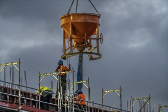 Concrete work, at dusk, on a large construction site building a residential and commercial complex,