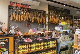 Spanish sausage shop with many hung hams and fresh delicacies in a cosy atmosphere, old town,