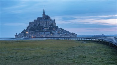 Mont Saint Michel in front of sunrise, rocky monastery island in the Wadden Sea, Le Mont Saint