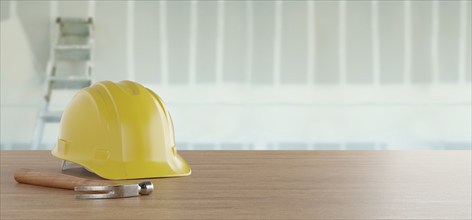 Yellow hard hat and hammer resting on a wood surface in front of drywall and ladder banner