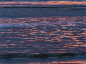 Abstract image of the North Sea, a evening mood with colorful pink reflections of the setting sun,