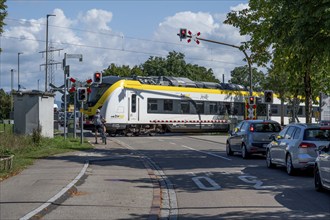 Regional train crossing a level crossing with barriers, Riegel am Kaiserstuhl, Baden-Württemberg,