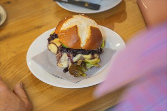 Close-up of a burger on a pretzel bun on a plate, autumn creations, Cafe Kuh, Deckenpfronn, Black