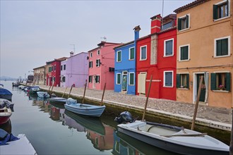 Colorful houses beside the waterway at 'Fondamenta Cao di Rio a Destra' with boats lying in the