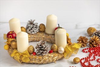 Festively decorated Advent wreath with white candles, craft materials next to it