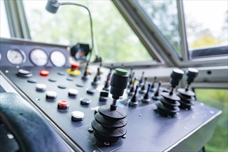 Black control panel with levers and buttons in cabin, Hermann Hesse Bahn track construction, Calw