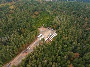 Forest with a construction site where wind power components are stored, surrounded by autumn