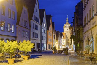 Galgengasse and White Tower in the old town of Rothenburg ob der Tauber, illuminated at night.