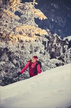 A woman's ski tour at sunrise on the Tegelberg in the Allgäu in the Ammergebirge, Bavaria, Germany,