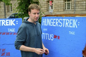 Titus Feldmann marks the 8th day of his hunger strike on a large board. Hunger strike camp,