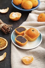 Truffle chocolate tangerine candies on a black concrete background and linen textile. Side view,