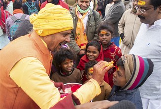 Children get painted the name of Lord Ram on their forehead, on the eve of consecration ceremony of