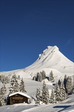 Snow-covered mountains and mountain hut with ski slope, Damülser Mittagspitze, Damüls,