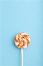 Single lollipop candy on blue pastel background. copy space, top view, flat lay