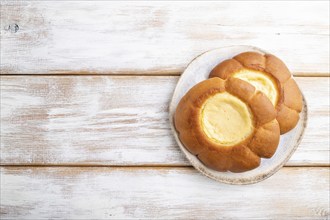 Sour cream bun on a white wooden background. top view, flat lay, copy space