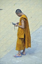 Monk with two mobile phones, Phnom Penh, Cambodia, Asia