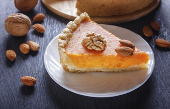 A slice of traditional american sweet pumpkin pie on black wooden background. close up