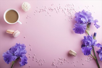 Purple iris flowers and a cup of coffee on a pink pastel background. Morninig, spring, fashion