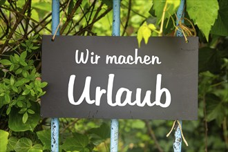 Symbolic image company holidays/holiday: sign in the garden with the inscription WIR MACHEN URLAUB