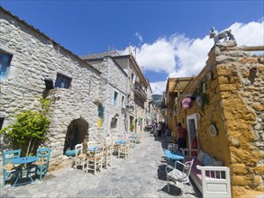 Sunny Mediterranean alley with alleyway cafés and locally run shops, Old Town, Areopoli, Areopolis,