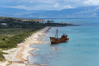 Old shipwreck on a sunny beach with a view of the sea and distant mountains, Dimitrios shipwreck,