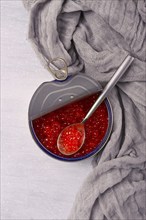 Tin can, with red caviar and a spoon, imitation, top view, right above, no people