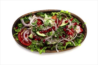 Salad of fresh vegetables, cucumbers, tomatoes, red onions, with nuts and pomegranate seeds, top