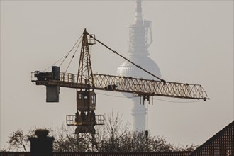 A crane looms in front of the Berlin television tower in Berlin, 29/02/2024