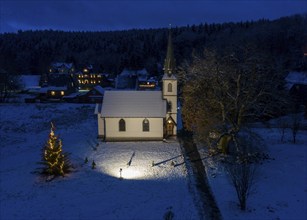 A Christmas tree stands in front of the smallest wooden church in Germany, Elend, 29 December 2020