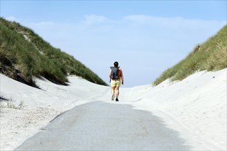 A woman walks to the beach on the island of Amrum, Norddorf, 15.06.2020